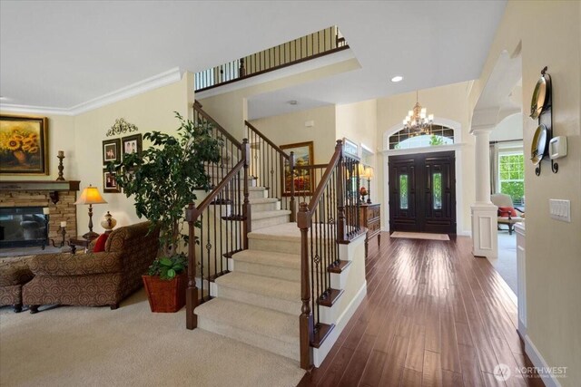 31045 219th Way SE, Black Diamond, WA 98010 - entryway with decorative columns, stairs, a chandelier, hardwood / wood-style floors, and baseboards
