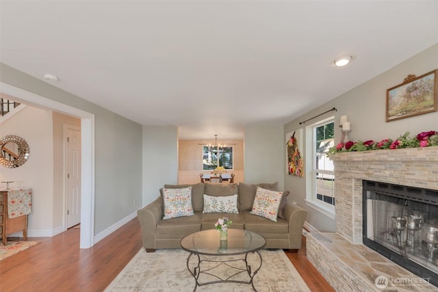 7611 176th Ave E, Bonney Lake, WA 98391 - living area featuring wood finished floors, baseboards, a chandelier, and a fireplace with raised hearth