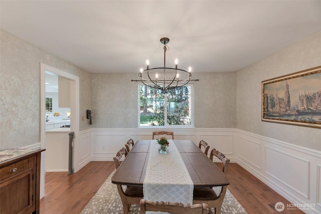 7611 176th Ave E, Bonney Lake, WA 98391 - dining space featuring a chandelier, dark wood finished floors, a wainscoted wall, and a decorative wall