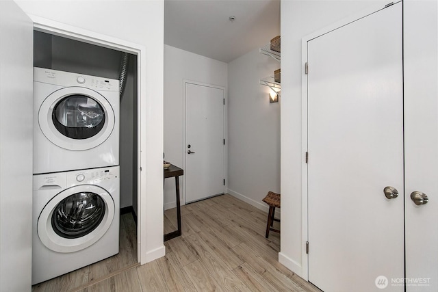 1414 12th Ave Unit 504, Seattle, WA 98122 - washroom with estacked washer and dryer, light wood-type flooring, and baseboards