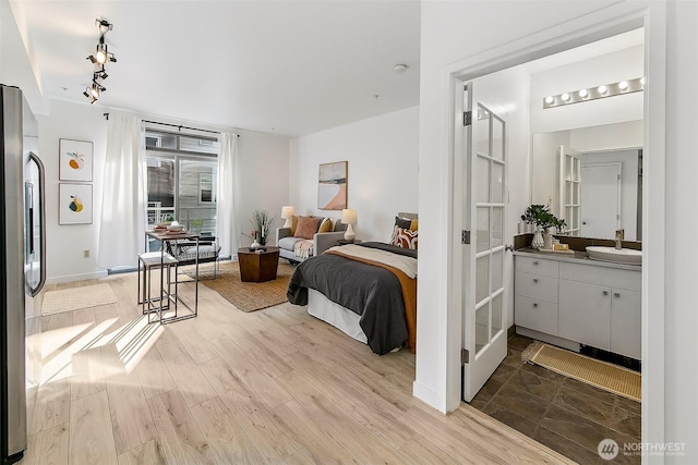1414 12th Ave Unit 504, Seattle, WA 98122 - bedroom featuring a sink, stainless steel fridge, wood finished floors, and rail lighting