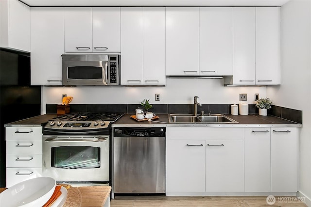 1414 12th Ave Unit 504, Seattle, WA 98122 - kitchen featuring stainless steel appliances, a sink, white cabinets, and dark countertops