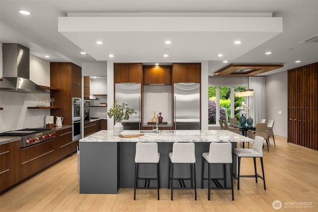 8926 NE 36th St, Yarrow Point, WA 98004 - kitchen featuring modern cabinets, stainless steel appliances, wall chimney range hood, a center island with sink, and recessed lighting