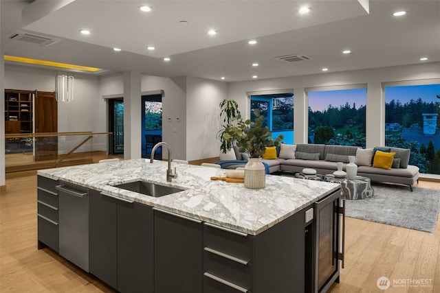 8926 NE 36th St, Yarrow Point, WA 98004 - kitchen with beverage cooler, a sink, open floor plan, a kitchen island with sink, and light wood-type flooring