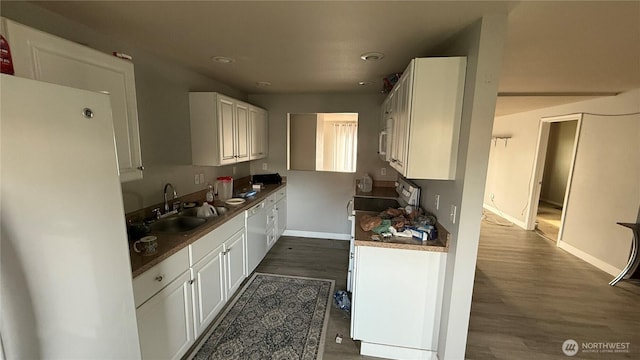 47 SE 10th St, College Place, WA 99324 - kitchen with a sink, baseboards, white cabinets, white appliances, and dark wood-style flooring