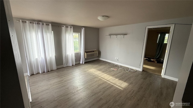 47 SE 10th St, College Place, WA 99324 - empty room with wood finished floors, baseboards, and a wall unit AC