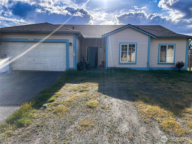 19904 13th Avenue Ct E, Spanaway, WA 98387 - view of front of property with asphalt driveway, an attached garage, roof with shingles, and a front lawn