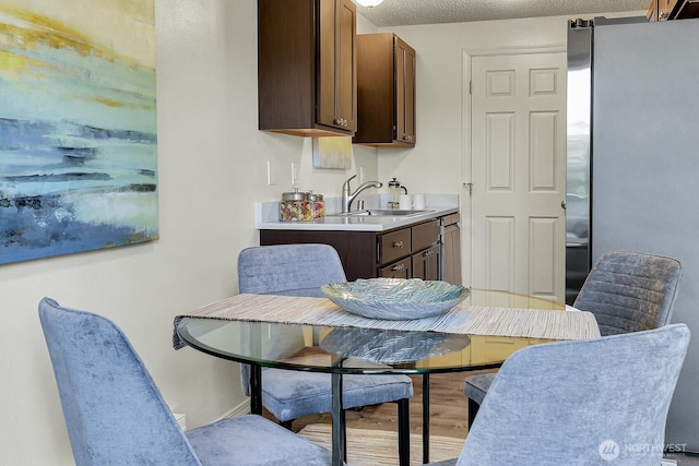 dining area featuring wood finished floors and a textured ceiling