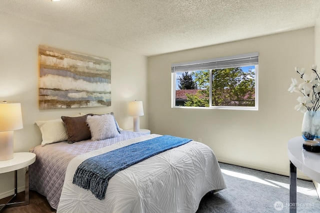 bedroom with a textured ceiling and baseboards