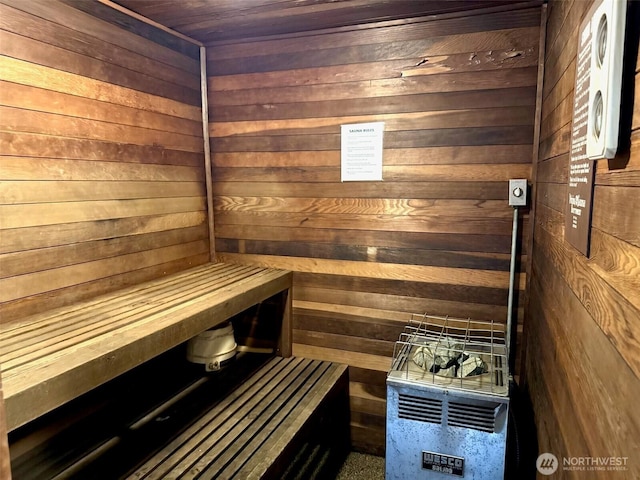 relaxing sauna featuring wooden walls and wood ceiling
