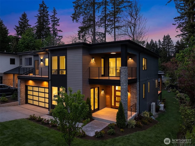 11320 113th Pl NE, Kirkland, WA 98033 - contemporary home with a balcony, a front lawn, an attached garage, stone siding, and concrete driveway