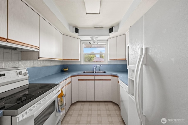 513 K St SW, Quincy, WA 98848 - kitchen with white appliances, a sink, light floors, decorative backsplash, and under cabinet range hood