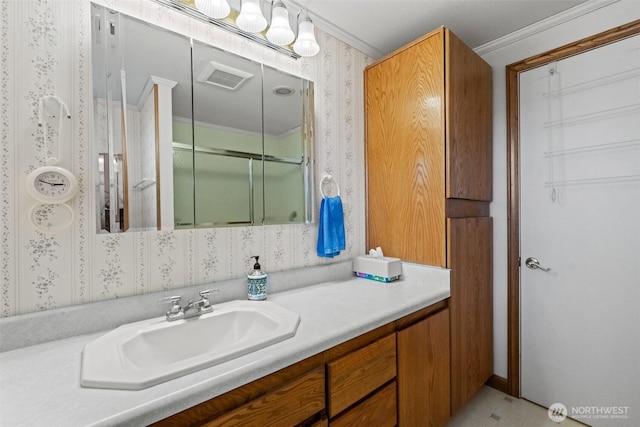 513 K St SW, Quincy, WA 98848 - bathroom with wallpapered walls, a shower with shower door, vanity, and ornamental molding