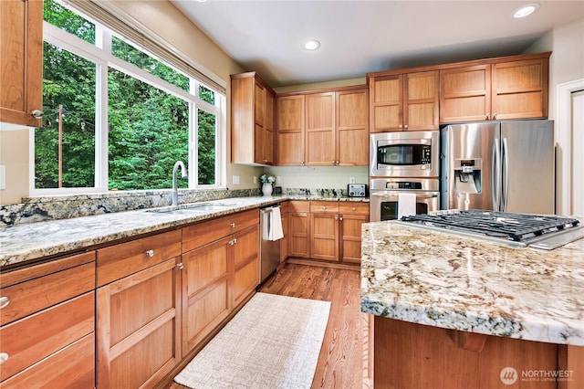 20524 73rd Dr SE, Snohomish, WA 98296 - kitchen with stainless steel appliances, a sink, light wood-type flooring, light stone countertops, and recessed lighting