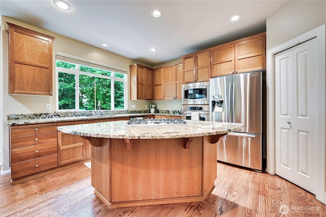 20524 73rd Dr SE, Snohomish, WA 98296 - kitchen with appliances with stainless steel finishes, light wood-type flooring, a breakfast bar area, a sink, and recessed lighting