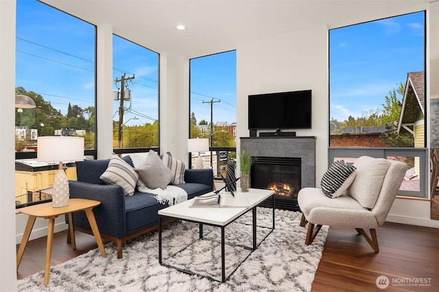 3818 S Hudson St Unit A, Seattle, WA 98118 - living area with wood finished floors, a glass covered fireplace, recessed lighting, baseboards, and expansive windows