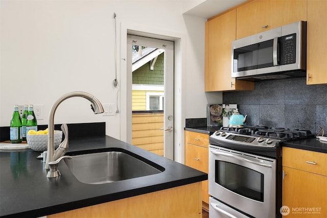 3818 S Hudson St Unit A, Seattle, WA 98118 - kitchen with stainless steel appliances, a sink, dark countertops, and backsplash