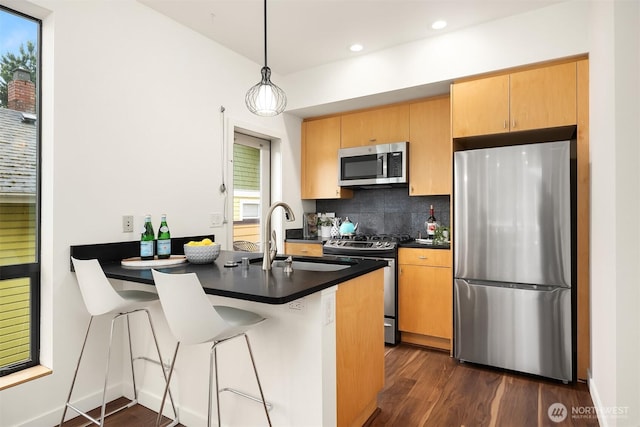 3818 S Hudson St Unit A, Seattle, WA 98118 - kitchen with stainless steel appliances, a sink, dark countertops, dark wood-type flooring, and recessed lighting