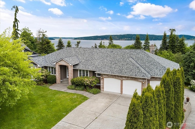 366 Samanthia Ln, Camano Island, WA 98282 - ranch-style home with an attached garage, brick siding, concrete driveway, a shingled roof, and a water view