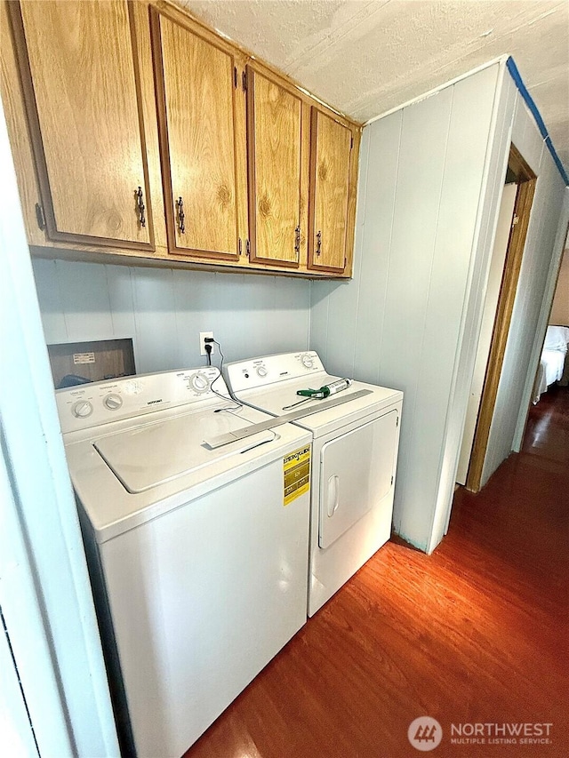 3333 SE 228th St Unit 105, Bothell, WA 98021 - laundry room with independent washer and dryer, cabinet space, wood finished floors, and a textured ceiling