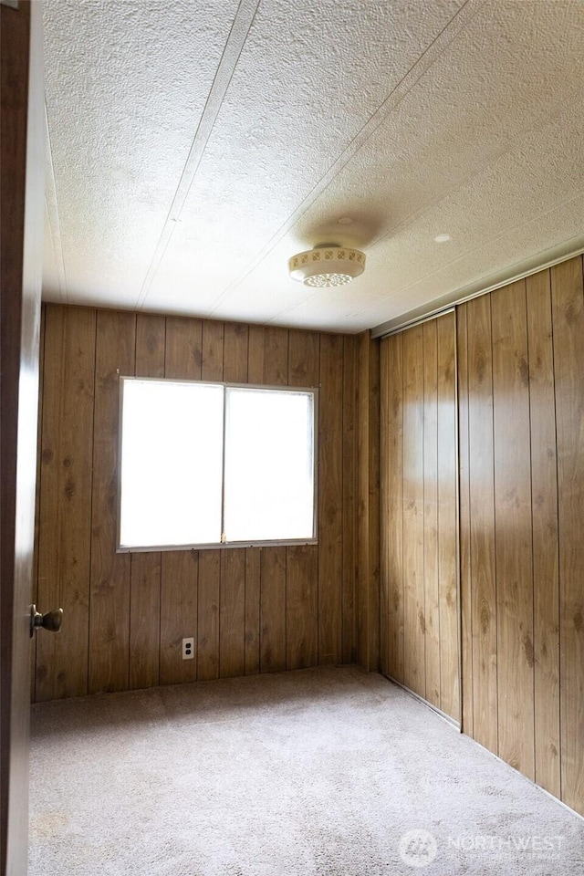 3333 SE 228th St Unit 105, Bothell, WA 98021 - spare room with a textured ceiling, carpet floors, wooden walls, and a smoke detector