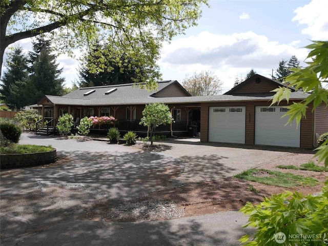 ranch-style home featuring decorative driveway and an attached garage