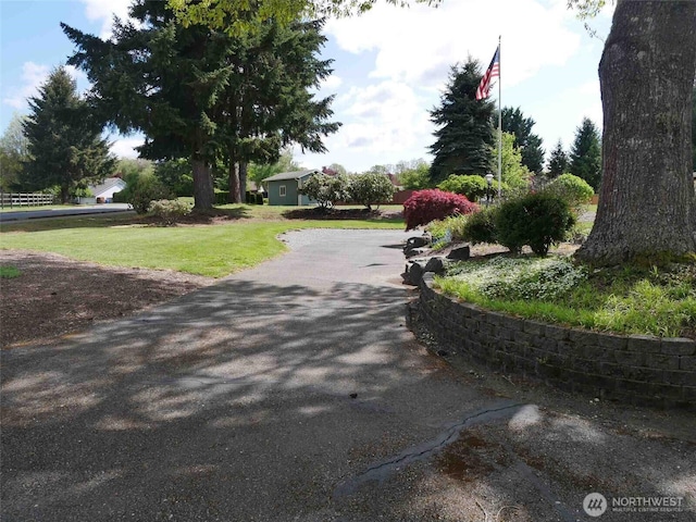 view of property's community featuring a yard and driveway