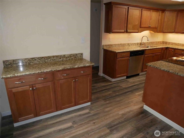 kitchen with stainless steel dishwasher, a sink, dark wood-style flooring, and brown cabinets
