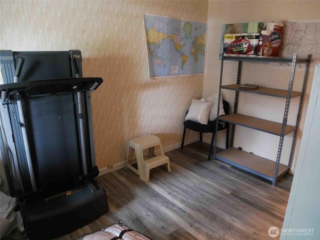 living area with wood finished floors, baseboards, and wallpapered walls