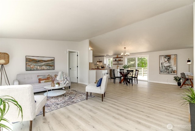 living room featuring a chandelier, light wood finished floors, lofted ceiling, and baseboards