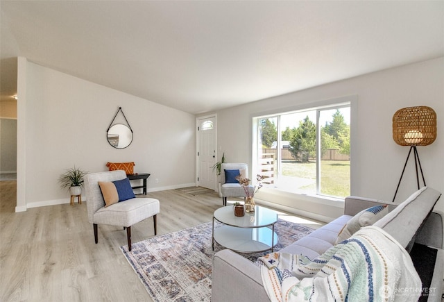 living area with light wood-type flooring and baseboards