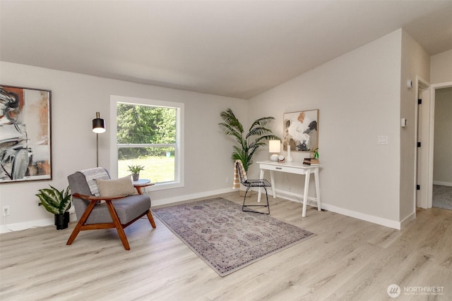 sitting room featuring wood finished floors, baseboards, and lofted ceiling