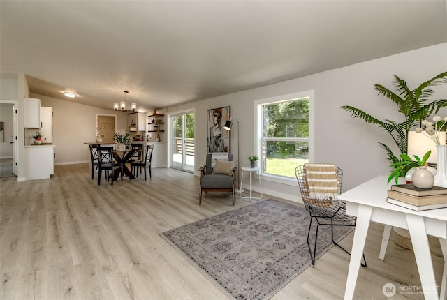 living area with a chandelier, baseboards, light wood-style flooring, and vaulted ceiling