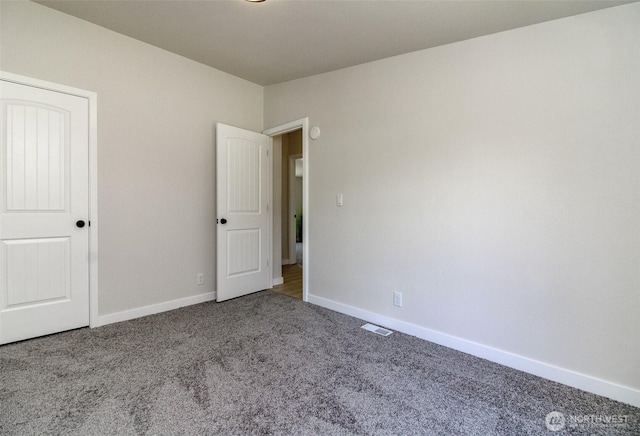 unfurnished bedroom with carpet floors and baseboards