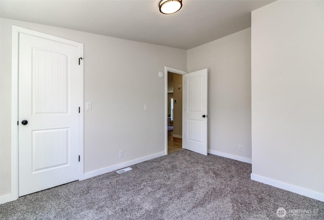 unfurnished bedroom featuring carpet flooring and baseboards