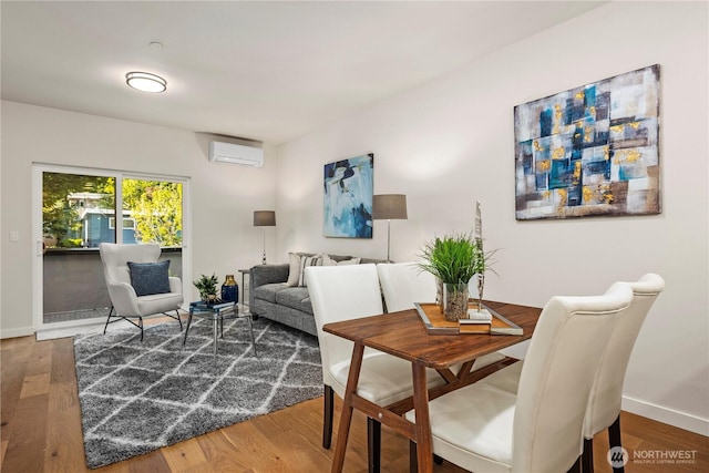105B NW 39th St, Seattle, WA 98107 - dining area featuring a wall mounted AC, wood finished floors, and baseboards