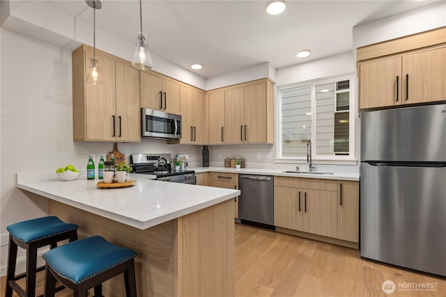 105B NW 39th St, Seattle, WA 98107 - kitchen with stainless steel appliances, a sink, light brown cabinets, a kitchen breakfast bar, and recessed lighting