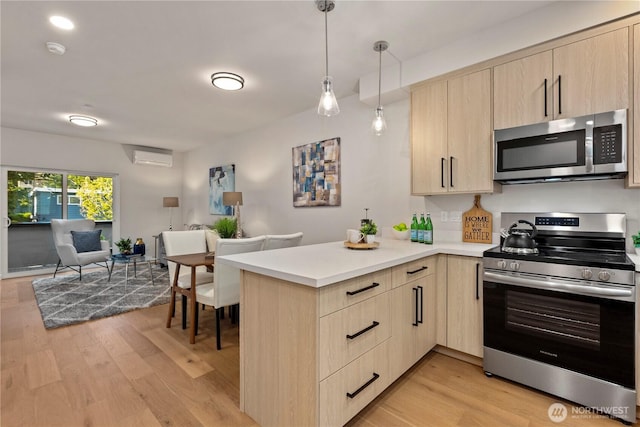 105B NW 39th St, Seattle, WA 98107 - kitchen featuring stainless steel appliances, light brown cabinetry, a peninsula, open floor plan, and light countertops