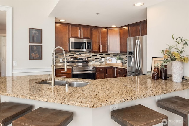 23503 55th Ave S, Kent, WA 98032 - kitchen featuring stainless steel appliances, a sink, light stone counters, recessed lighting, and backsplash