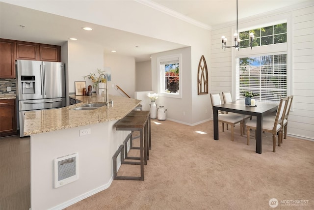 23503 55th Ave S, Kent, WA 98032 - kitchen with a sink, stainless steel fridge, a chandelier, light stone counters, and baseboards