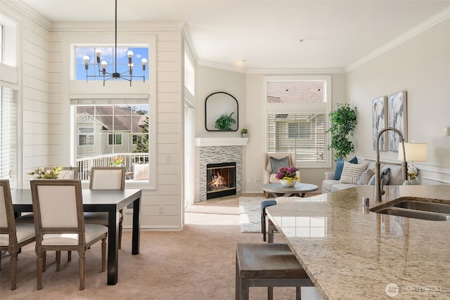 23503 55th Ave S, Kent, WA 98032 - dining space featuring a chandelier, a tiled fireplace, crown molding, and light colored carpet