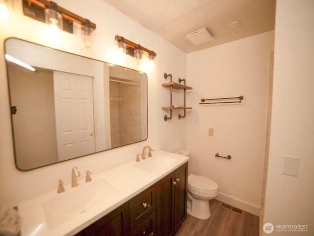 2840 SW 342nd St, Federal Way, WA 98023 - bathroom with double vanity, wood finished floors, a shower, and a textured ceiling