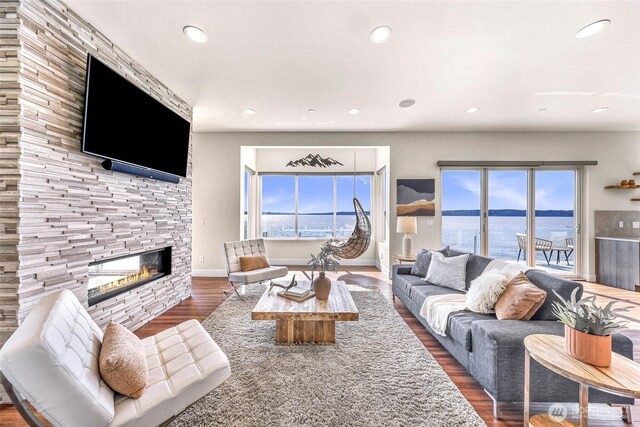 12065 30th Ave SW, Burien, WA 98146 - living room featuring healthy amount of natural light, wood finished floors, a stone fireplace, recessed lighting, and a water view