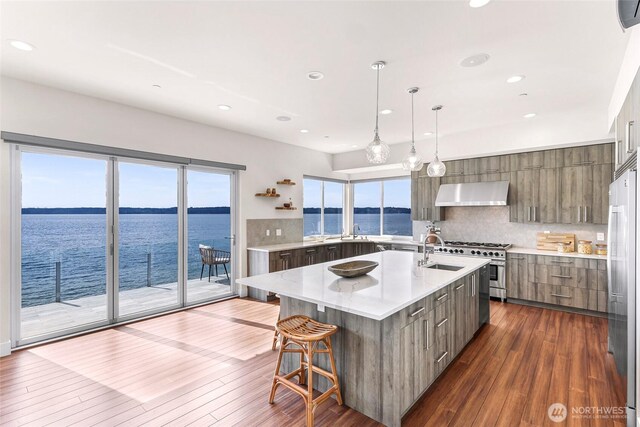 12065 30th Ave SW, Burien, WA 98146 - kitchen with modern cabinets, wall chimney range hood, a sink, a water view, and recessed lighting