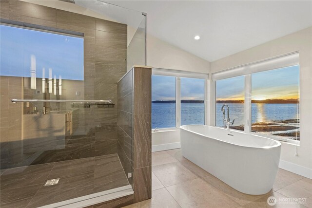 12065 30th Ave SW, Burien, WA 98146 - full bathroom featuring tile patterned floors, a freestanding bath, a tile shower, lofted ceiling, and a water view