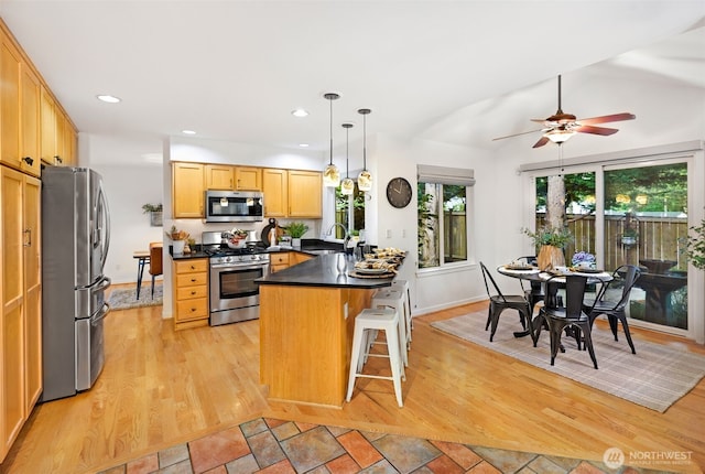 10820 NE 144th Ct, Kirkland, WA 98034 - kitchen featuring appliances with stainless steel finishes, a peninsula, light wood-style flooring, dark countertops, and a sink
