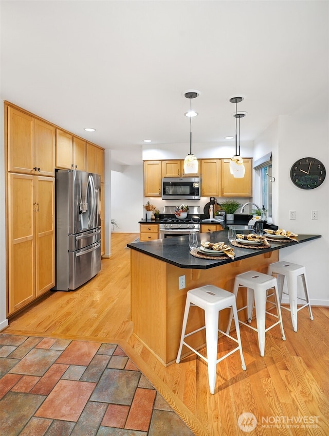10820 NE 144th Ct, Kirkland, WA 98034 - kitchen with appliances with stainless steel finishes, a peninsula, dark countertops, a kitchen bar, and recessed lighting