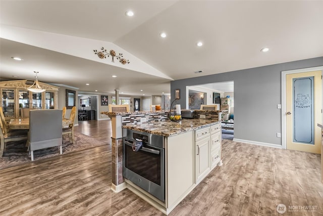 3001 163rd St E, Tacoma, WA 98446 - kitchen with oven, open floor plan, lofted ceiling, light stone countertops, and light wood-style flooring