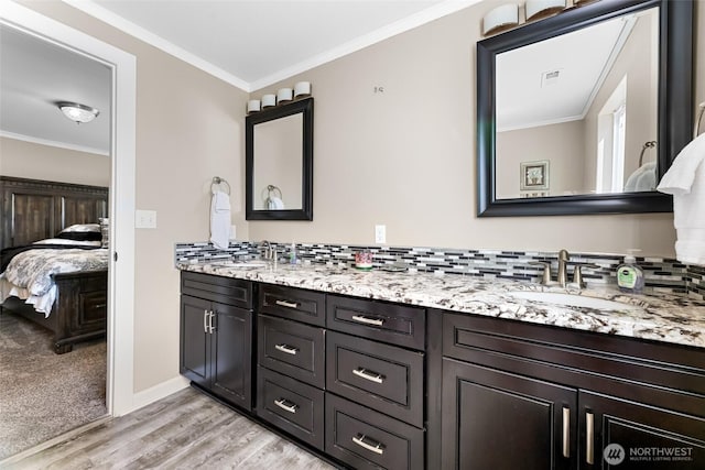 3001 163rd St E, Tacoma, WA 98446 - bathroom featuring ensuite bathroom, double vanity, wood finished floors, ornamental molding, and decorative backsplash