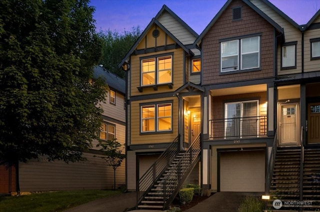 2743 SW Sylvan Heights Dr, Seattle, WA 98106 - view of front of house with stairway, an attached garage, asphalt driveway, and board and batten siding